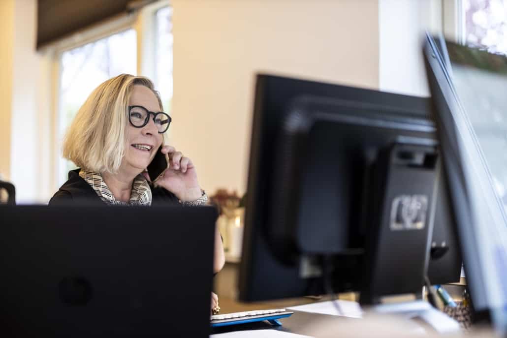 Kvindelig rådgiver taler i telefon for at vejlede en kunde om gratis inkasso.