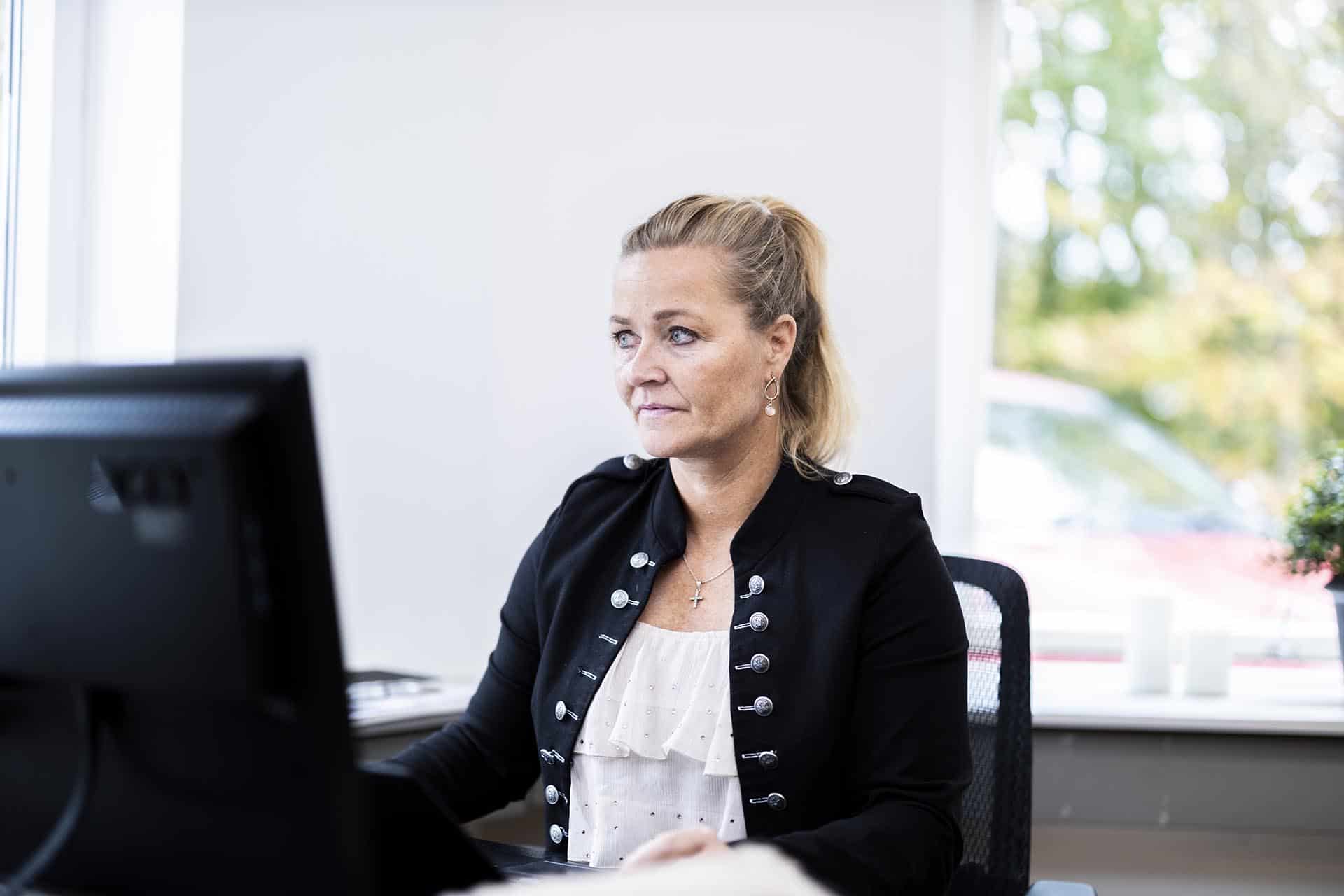 Kvindelig ansat hos Inkasso Mægleren skriver fokuseret på sit tastatur.