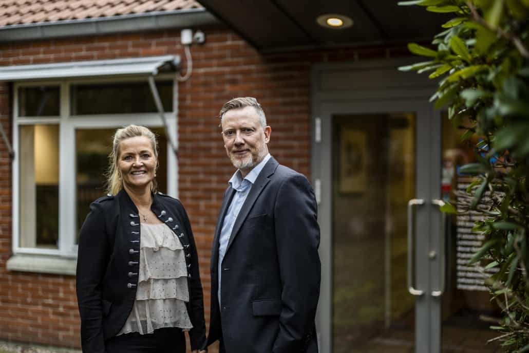 To medarbejdere i dialog foran indgangen til vores inkassovirksomhed.